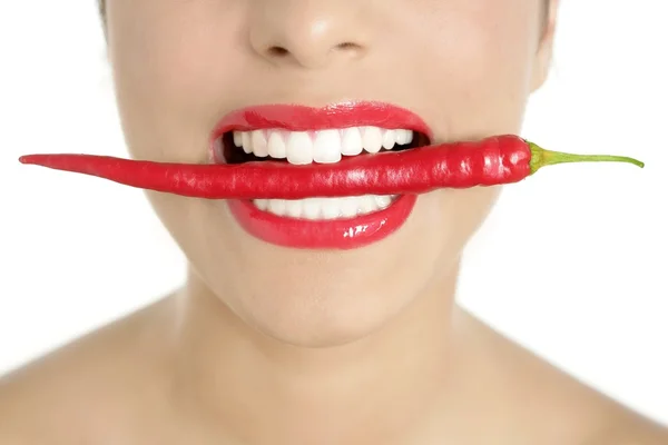 Beautiful woman teeth eating red pepper — Stock Photo, Image