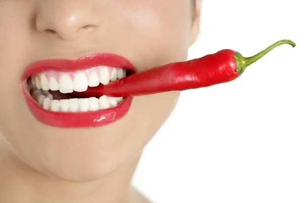 Vacker kvinna tänder äta röd paprika — Stockfoto