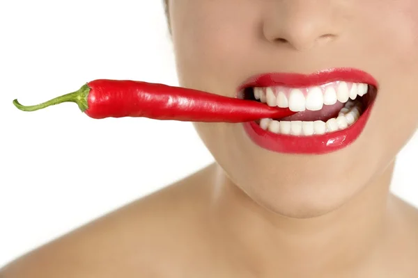 Mulher bonita dentes comendo pimenta vermelha — Fotografia de Stock