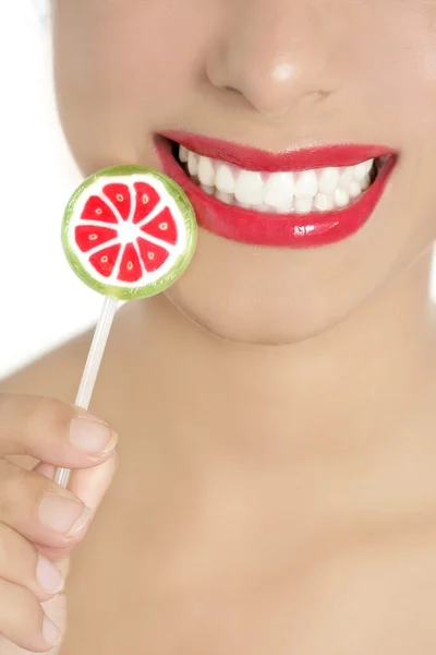 Kleurrijke lolly in perfecte vrouw tanden — Stockfoto