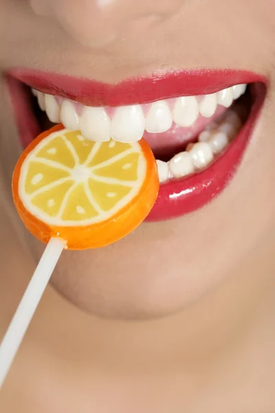 Colorful Lollypop in perfect woman teeth — Stock Photo, Image
