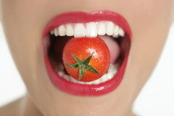 Comer uma macro de tomate vermelho da boca da mulher — Fotografia de Stock