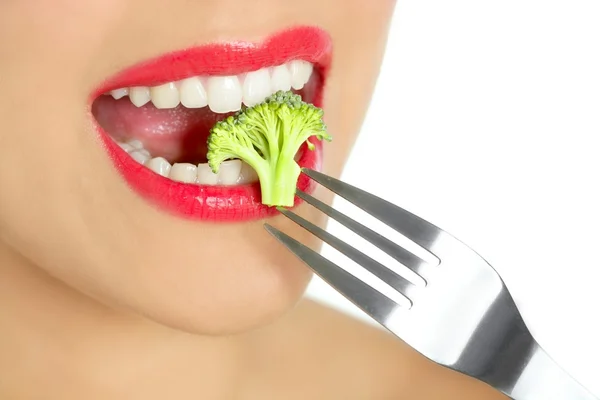 Brócolis em garfo de aço na boca da mulher — Fotografia de Stock