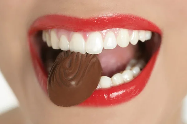 Chocolate sweet in beautiful woman mouth — Stock Photo, Image