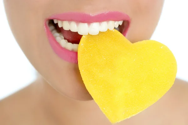 Καρδιά σχήμα καραμέλα στο στόμα μακροεντολή γυναίκα — Φωτογραφία Αρχείου