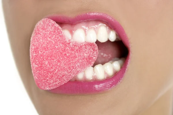 Hart vorm suikergoed op vrouw macro mond — Stockfoto