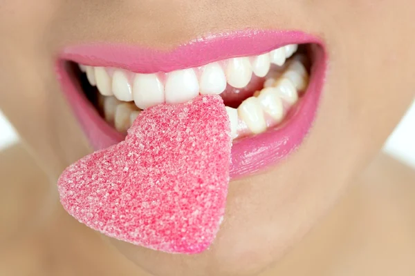 Srdce tvar cukroví na ženu makro ústí — Stock fotografie