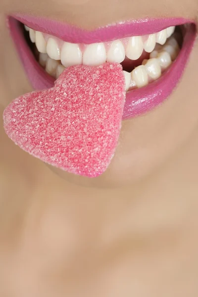 Srdce tvar cukroví na ženu makro ústí — Stock fotografie