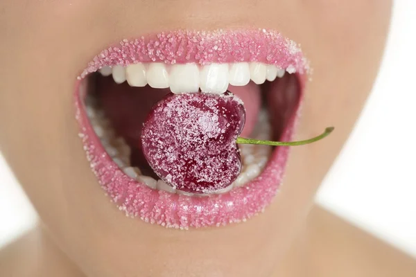 Cherry with sugar in woman teeth mouth — Stock Photo, Image