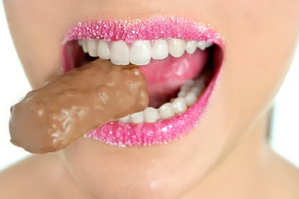 Chocolade sweet in mooie vrouw mond — Stockfoto