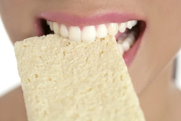 Печенье в женских зубах и рту, здоровые закуски — стоковое фото