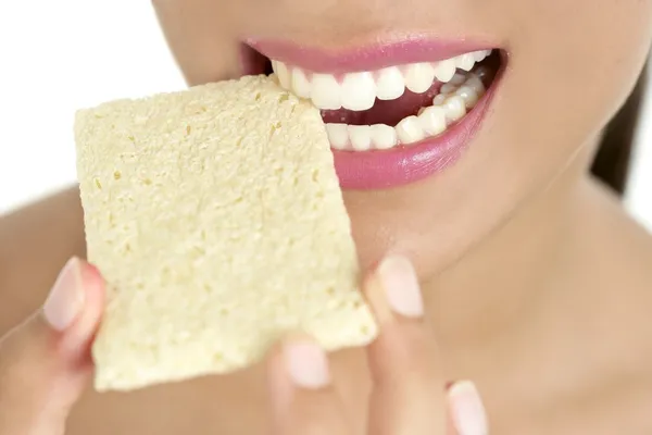Sušenky v žena zuby a ústa, zdravá svačina — Stock fotografie