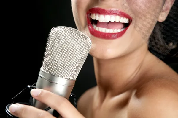 Hermosa mujer cantando en un micrófono vintage — Foto de Stock