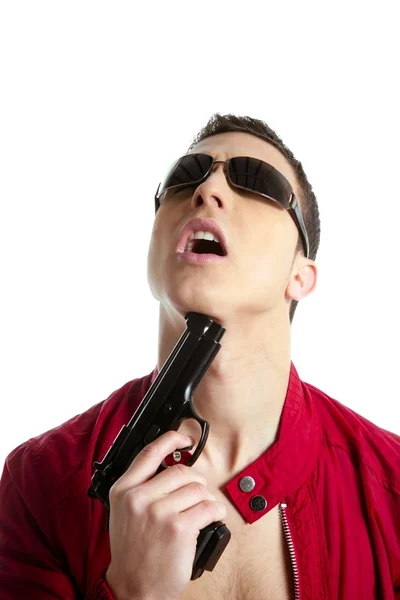 Молодой человек с пистолетом, притворяющийся самоубийцей — стоковое фото
