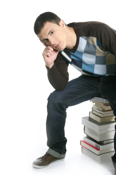 Jovem estudante sentado sobre livros pilha — Fotografia de Stock