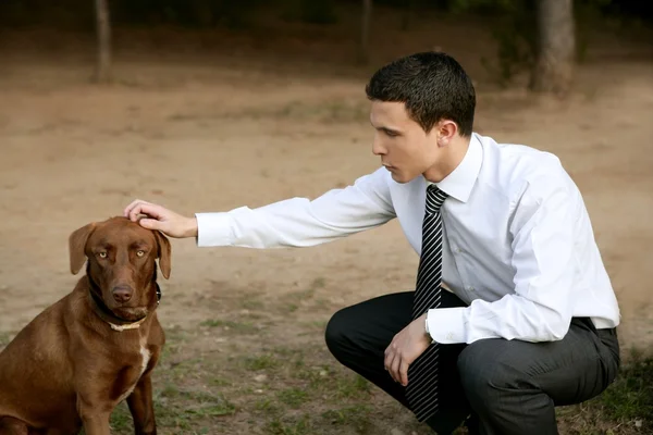 Businessman with dog outdoor in park — Stock Photo, Image