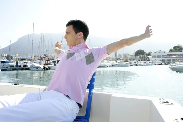 Junger schöner Mann entspannt auf seinem Boot — Stockfoto
