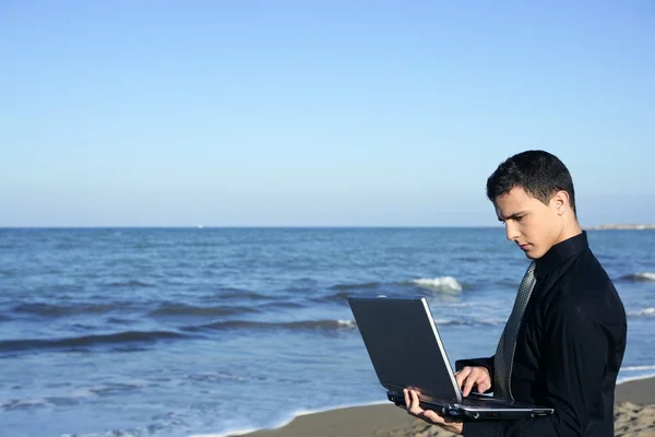 Stilig ung affärsman dator beach — Stockfoto