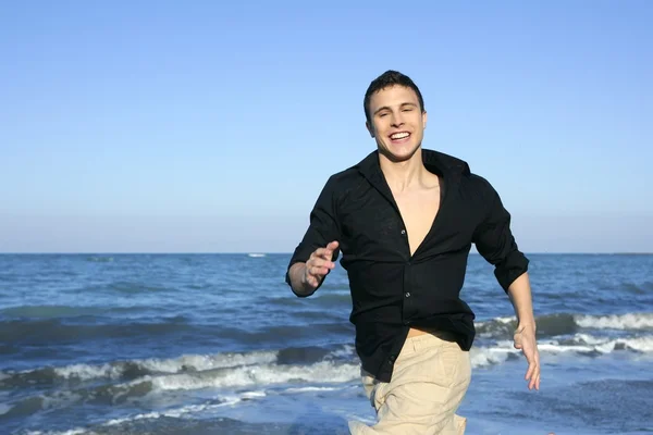 Uomo che corre felice sulla spiaggia blu estiva — Foto Stock