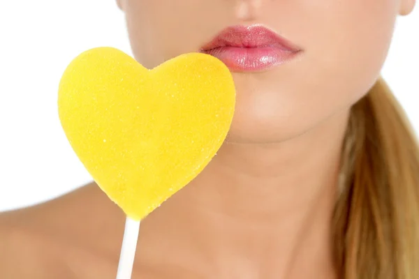 Heart shape candy on woman macro mouth — Stock Photo, Image