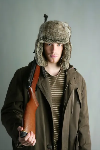 Myśliwy mężczyzna futro zimowe kapelusz gospodarstwa karabin maszynowy — Zdjęcie stockowe