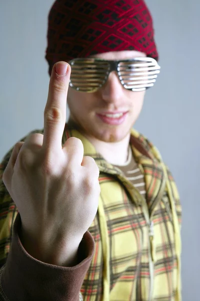 Середній палець нецензурний жест молодої шапки людини — стокове фото