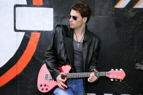 Rock star hombre graffiti negro sosteniendo la guitarra eléctrica — Foto de Stock