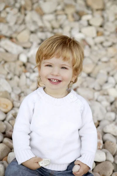 Blonde jongen glimlachen op de achtergrond van een rolling stones — Stockfoto