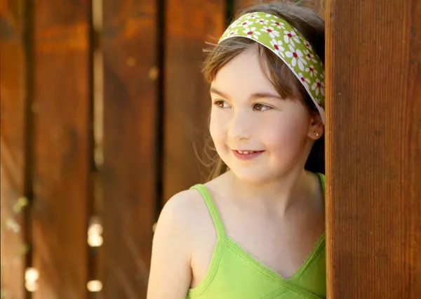 Schönes junges Mädchen hinter der Holztür — Stockfoto