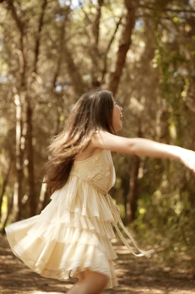 Teen girl dancing in the brown pine forest — Stock Photo, Image