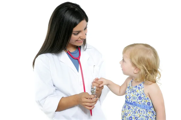Brunette pediatric doctor with blond little girl Stock Picture