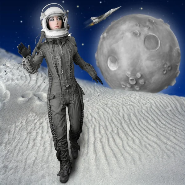 宇航员时尚站在女人的航天服的头盔 图库照片