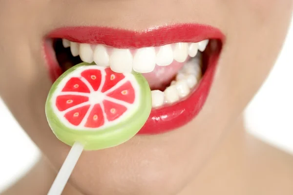 Colorful Lollypop in perfect woman teeth Royalty Free Stock Photos