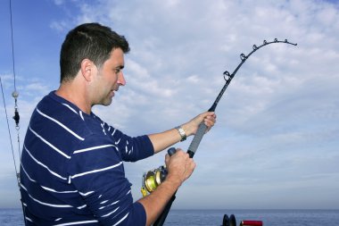 Angler fisherman fighting big fish rod and reel clipart