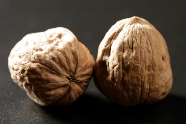 Walnuts with shells over black background clipart