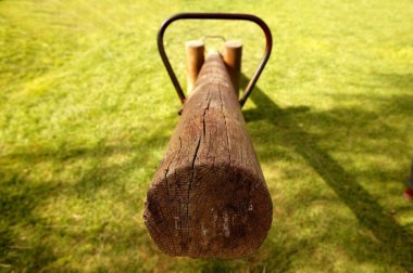 Old wooden teeter totter in the park clipart