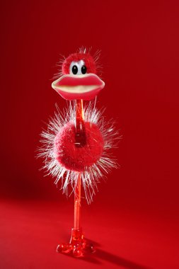Funny red ostrich toy with candy hot lips clipart