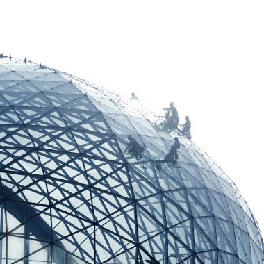 Workers cleaning a round glass facade