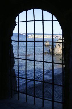 Blue sea behind the jail, arch window clipart