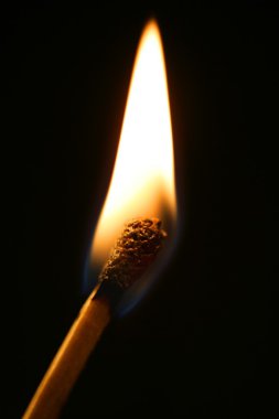 One match in flame over black background clipart