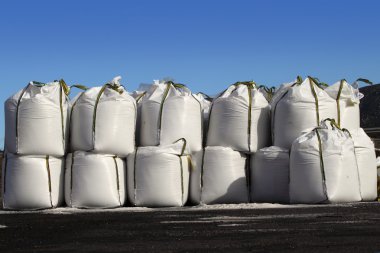 Salt big bags sacks stacked rows for iced roads clipart