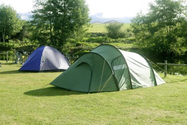 Yeşil çimenlerin üzerinde kamp çadır alanı