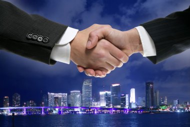 Businessman handshake in Miamy downtown night clipart