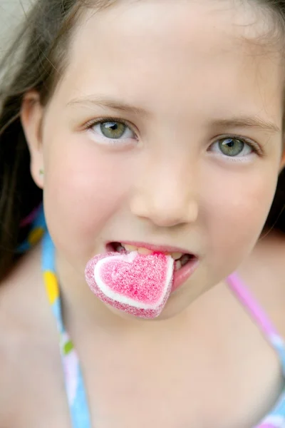 Красивый подростковый портрет, поедающий конфетное сердце — стоковое фото