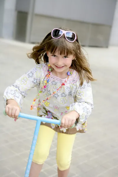 Bruna bambina con scooter in città — Foto Stock