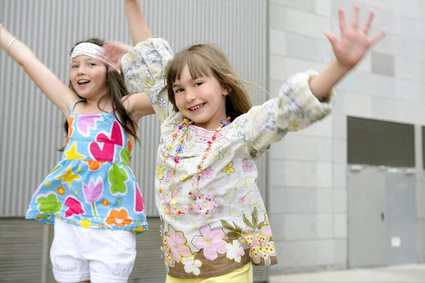 Twee kleine meisjes dansen in de stad — Stockfoto