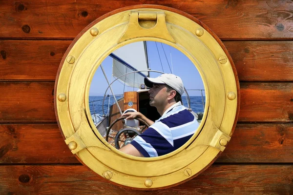 Sailor on sailboat, from boat round window — Stock Photo, Image
