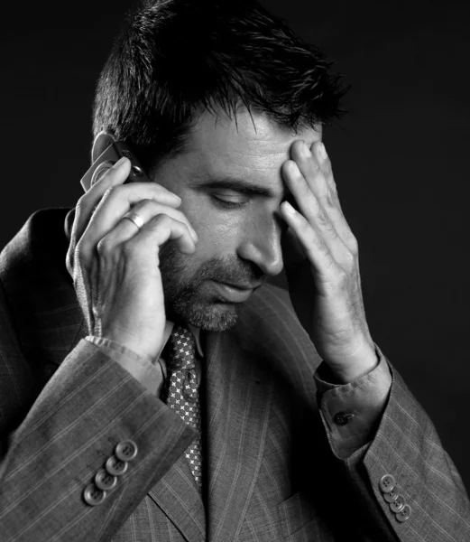 Businessman with headache and mobile phone — Stock Photo, Image