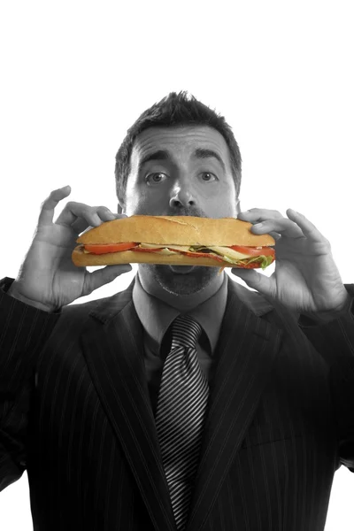 Бизнесмен ест нездоровую сэндвич-еду — стоковое фото