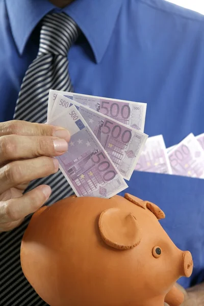 Affärsman infoga eurosedlar i spargris — Stockfoto